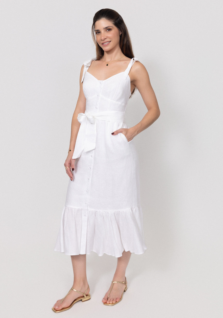 Woman wearing a Buttoned Linen Midi Dress With Tie Straps and Ruffled Hem with a bow tie on a plain background
