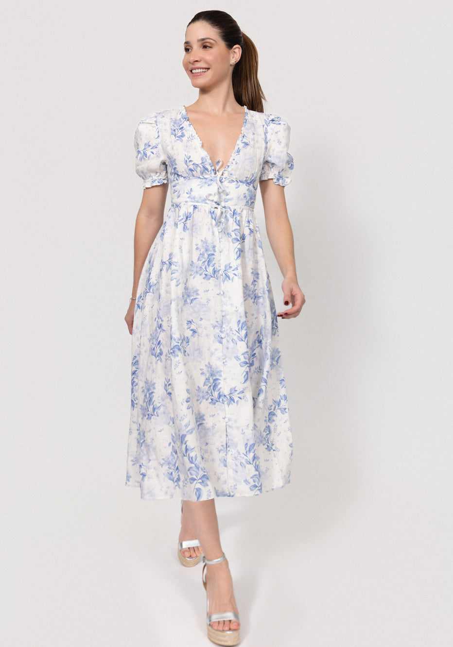 Woman wearing a floral Linen Button-Front Midi Dress with Puff Sleeves & Tie Detail on a white background