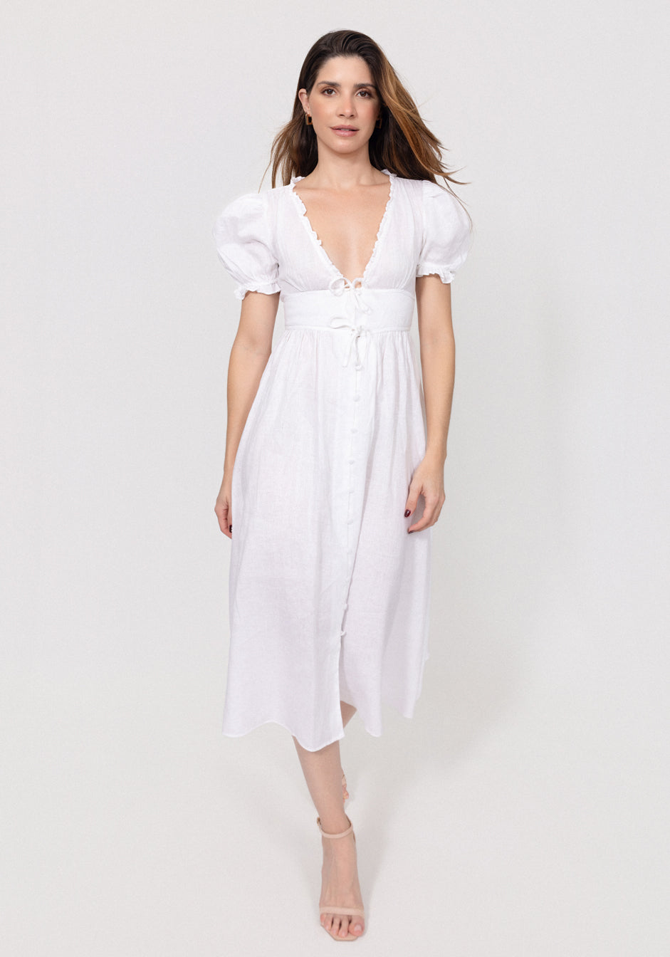 Woman wearing a white Linen Button-Front Midi Dress with Puff Sleeves & Tie Detail on a plain background