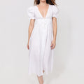 Woman wearing a white Linen Button-Front Midi Dress with Puff Sleeves & Tie Detail on a plain background
