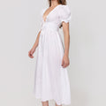 Woman wearing a white Linen Button-Front Midi Dress with Puff Sleeves & Tie Detail on a plain background
