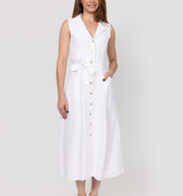 Woman wearing a white sleeveless linen dress on a plain background