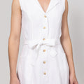 White sleeveless dress with buttons with waist tie on a plain background