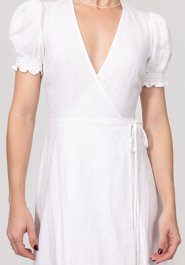 White dress with short sleeves and a deep neckline on a plain background