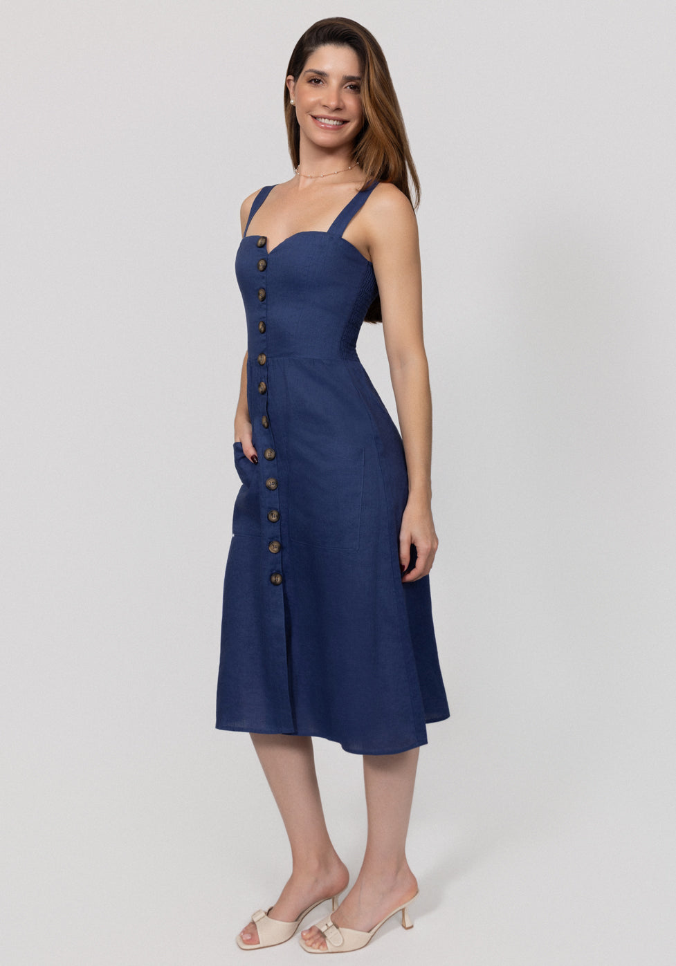 Woman wearing a blue Midi Linen Dress With Front Buttons & Pockets with button details on a white background