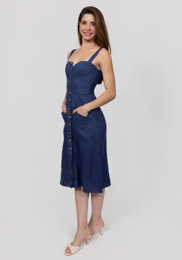 Woman wearing a navy blue dress with buttons on a white background