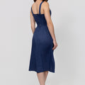 Woman wearing a navy blue dress on a white background from the back