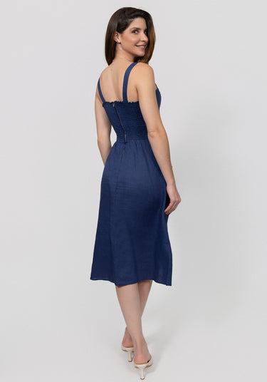 Woman wearing a navy blue dress on a white background from the back