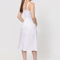 Woman wearing a white dress on a plain background