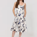 Woman wearing a floral Romantic Linen Midi Dress With Front Tie & Soft Ruffle on a white background