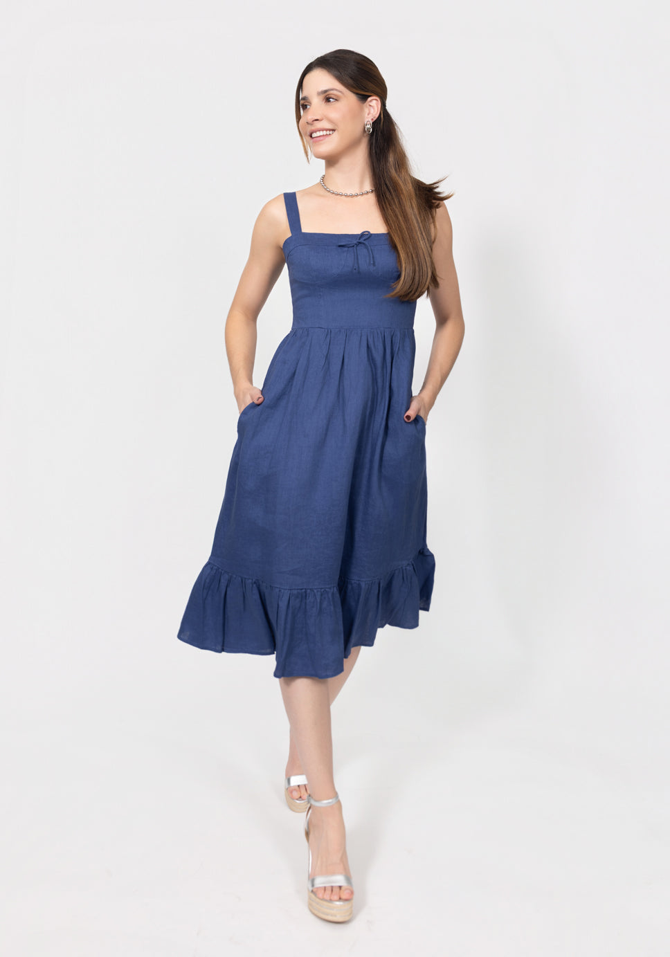Woman wearing a navy blue Romantic Linen Midi Dress With Front Tie & Soft Ruffle against a white background