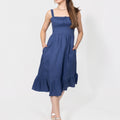 Woman wearing a navy blue Romantic Linen Midi Dress With Front Tie & Soft Ruffle against a white background