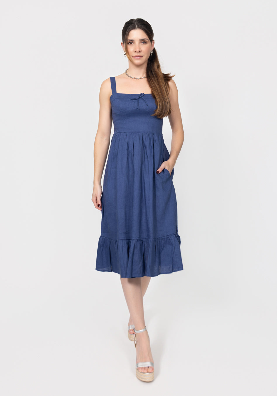 Woman wearing a blue linen dress on a white background