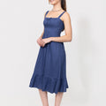Woman wearing a blue Romantic Linen Midi Dress With Front Tie & Soft Ruffle on a white background