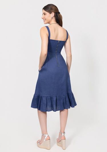 Woman wearing a blue dress with a ruffled hem on a white background